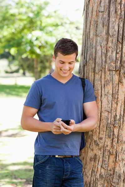 Hombre joven musculoso usando un teléfono inteligente —  Fotos de Stock