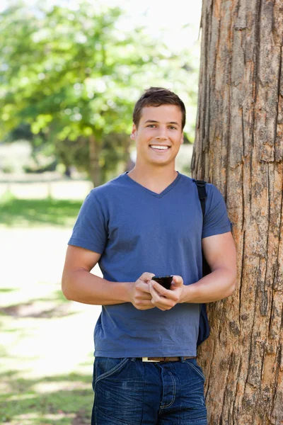 Portrait of a muscled young man using a smartphone — Stock Photo, Image