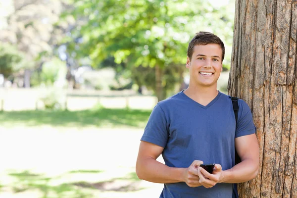 Porträtt av en muskulös ung man med en smartphone — Stockfoto