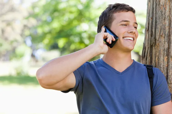 Close-up van een gespierde student op de telefoon — Stockfoto