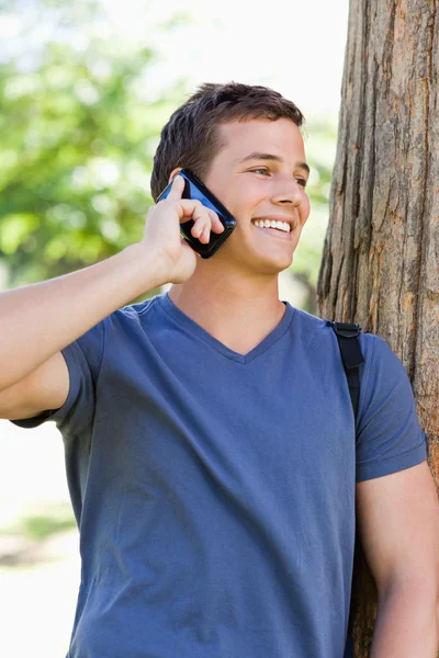 Primo piano di un giovane sorridente al telefono — Foto Stock
