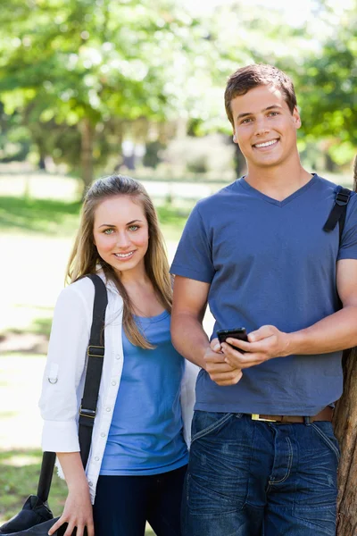 Porträtt av två studenter med en smartphone — Stockfoto