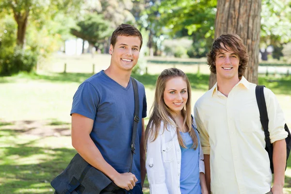 Portrait of smiling students with their bags — Stock Photo, Image