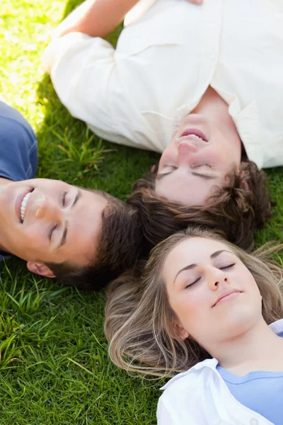 Drie gelukkige studenten samen rusten — Stockfoto