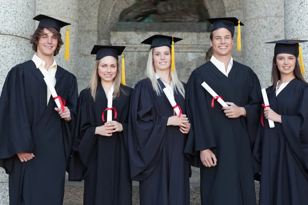 Sorrindo graduados posando — Fotografia de Stock