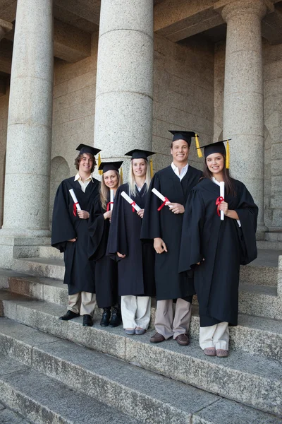 Laughing graduates posing the thumb-up — Stock Photo, Image