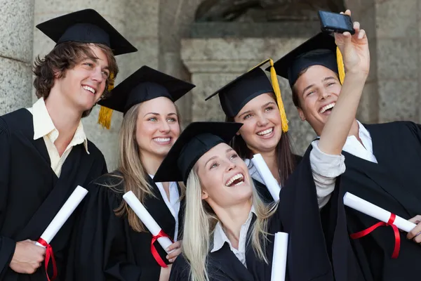 Gros plan de diplômés heureux prenant une photo d'eux-mêmes — Photo