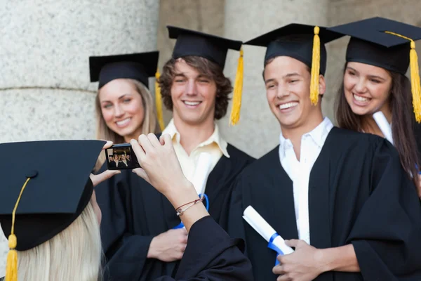 Gros plan d'une diplômée prenant une photo de son amie souriante — Photo