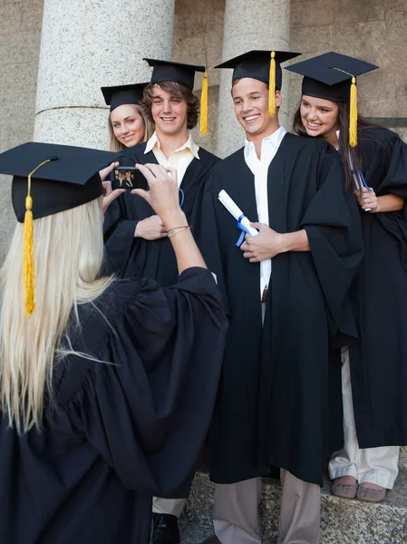 Blonde graduate taking a picture of her friend — Stock Photo, Image