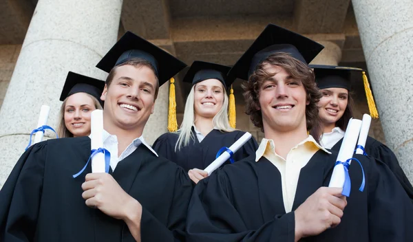 Låg vinkel-shot graduate poserar — Stockfoto