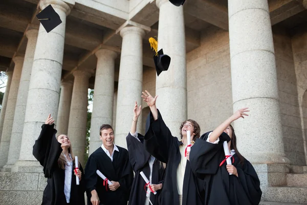 Les diplômés jetant leurs chapeaux dans le ciel — Photo