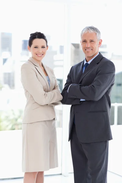 Secretaria y su directora se muestran sonriendo frente al windo — Foto de Stock