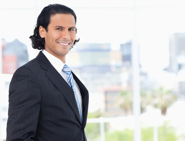 Young executive proudly standing in front of a window — Stock Photo, Image