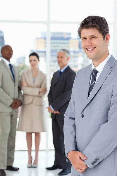 Серьезный бизнес-команда глядя на улыбающийся исполнительный перед — стоковое фото