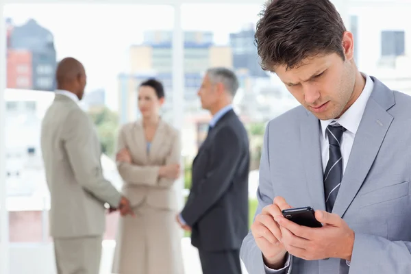 Joven gerente serio usando su teléfono celular para enviar un mensaje de texto — Foto de Stock