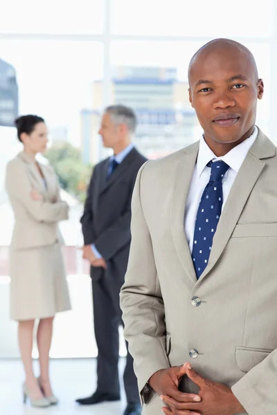 Empresario con traje y cruzando las manos con su equipo — Foto de Stock