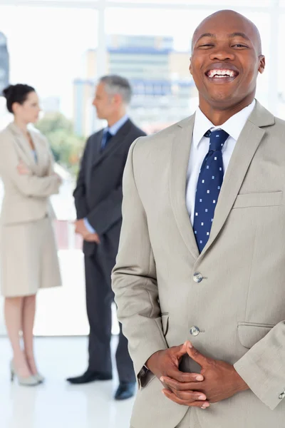 Joven hombre de negocios riendo de pie con las manos en alto — Foto de Stock