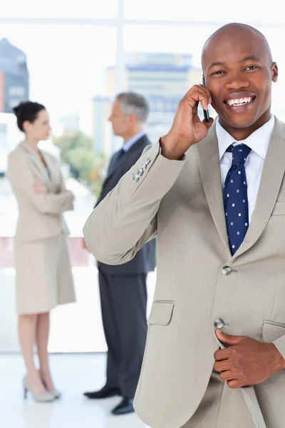 Manager mit Handy beim Aufknöpfen seiner Anzugjacke — Stockfoto