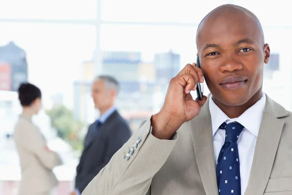 Ernstige zakenman in een pak praten over de telefoon terwijl zijn thee — Stockfoto