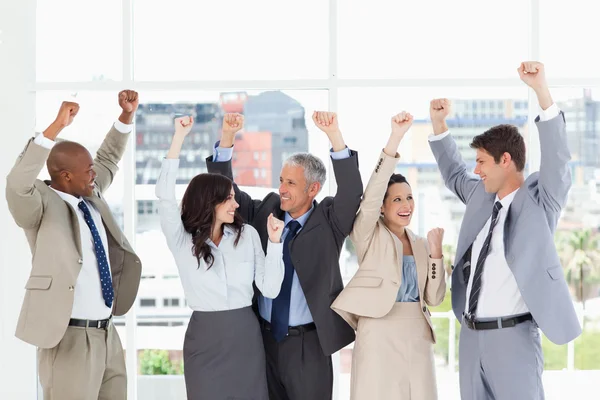 Vijf business op zoek naar elkaar en het verhogen van hun arm — Stockfoto