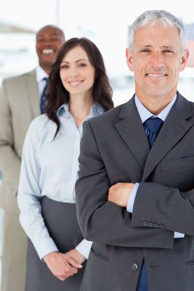 Matura manager in un abito seguito da due giovani imprese — Foto Stock