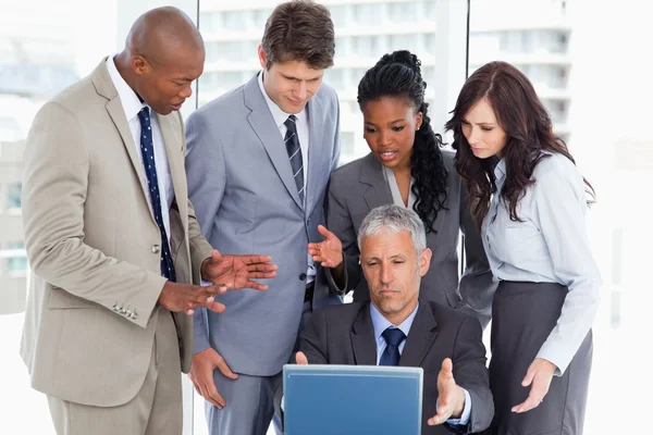 Business team seriously talking in front of a laptop — Stock Photo, Image