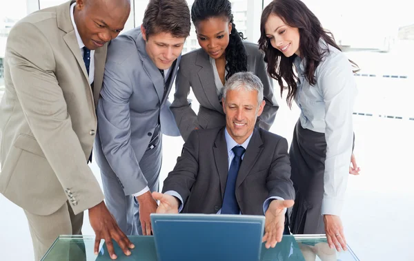 Mature manager sitting at the desk surrounded by his serious tea — Stock Photo, Image