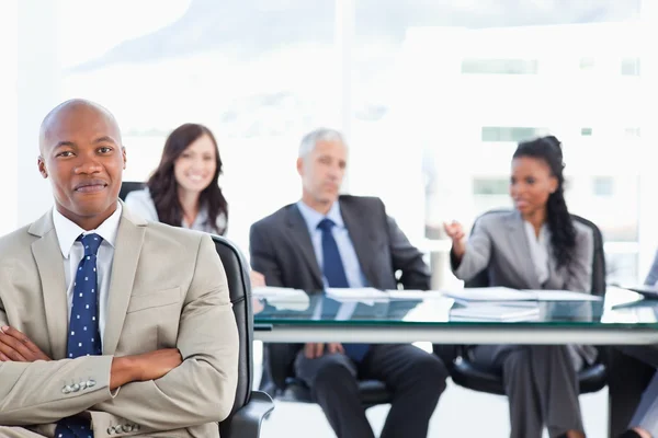 Young businessman almost smiling in front of his team who are si — Stock Photo, Image