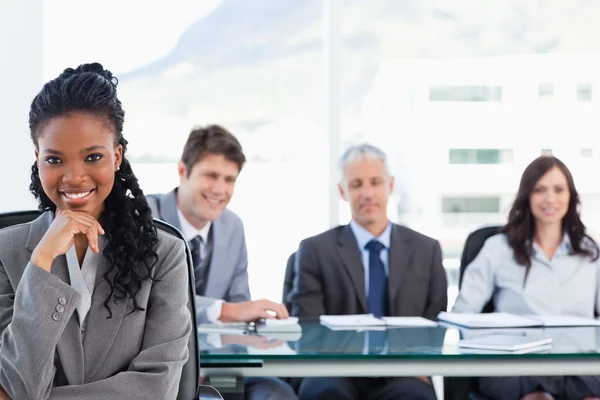 Vertrouwen uitvoerend zitten in een vergaderzaal, terwijl haar team is — Stockfoto