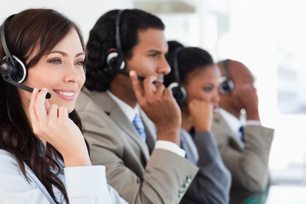 Smiling call centre employee working while accompanied by her te — Stock Photo, Image