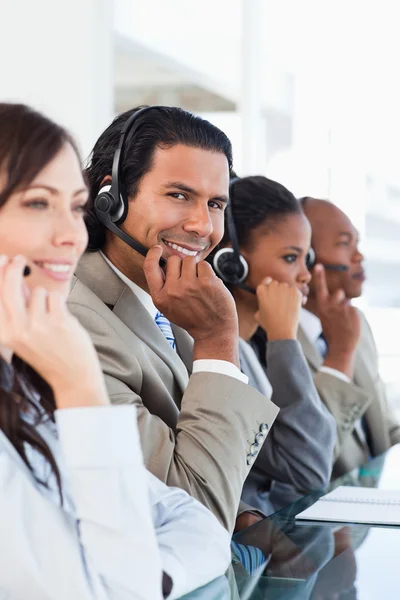 Ung leende call centre arbetstagare arbetar bland hans business team — Stockfoto