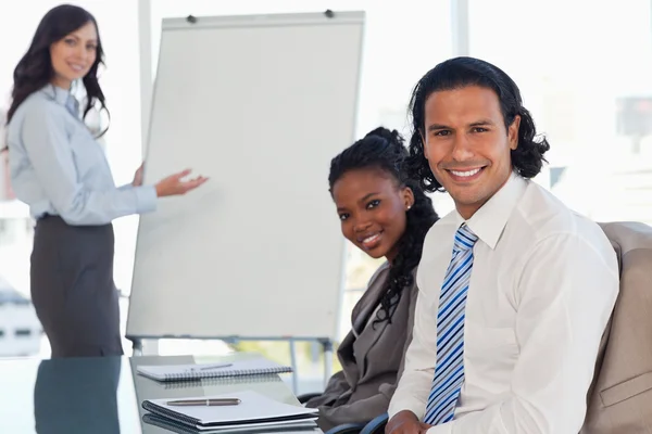 Two smiling employees sitting at a desk in a meeting room during — Stock Photo, Image