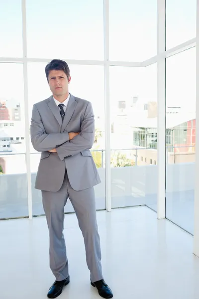 Stern businessman standing in a well-lit area — Stock Photo, Image