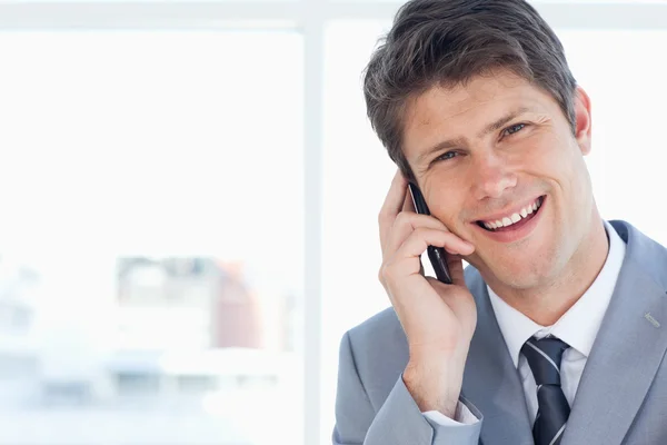 Jonge zakenman lachen tijdens het gesprek op de telefoon — Stockfoto