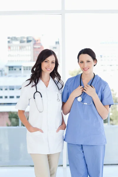 Två unga medicinska praktikanter bär deras sjukhus uniform — Stockfoto