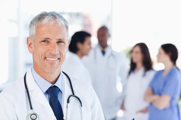 Mature doctor standing upright while waiting for his team — Stock Photo, Image