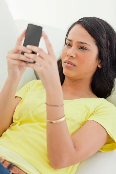 Nahaufnahme eines Latinos, der beim Anblick seines Smartphones die Stirn runzelt — Stockfoto