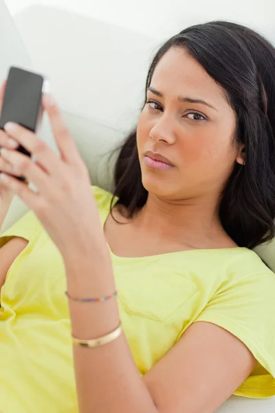 Portrait of a sad Latino holding her smartphone — Stock Photo, Image