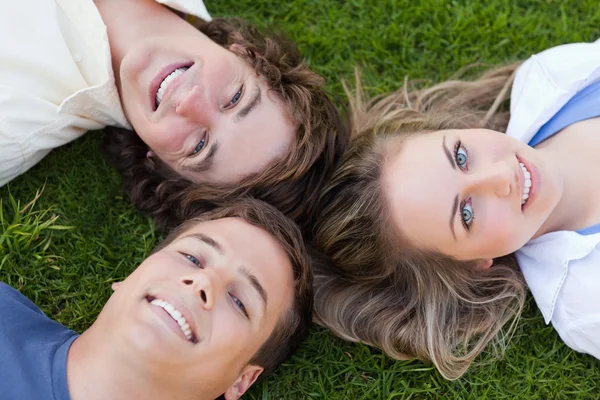 Close-up on three students lying together — Stock Photo, Image