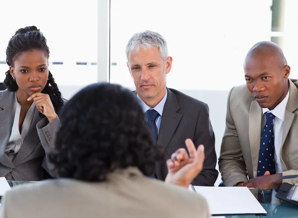 Three business attentively listening to a speaker in a me — Stock Photo, Image