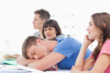 A sleeping student is being looked at by a confused fellow stude clipart