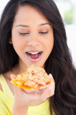 Close up of a woman looking at the slice of pizza she is about t clipart