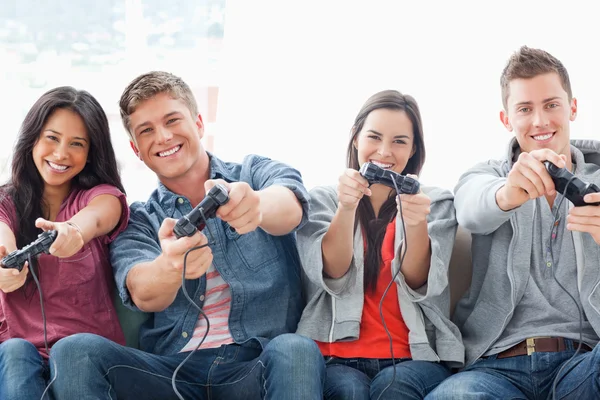 Um grupo brilhantemente sorrindo jogando um jogo juntos — Fotografia de Stock