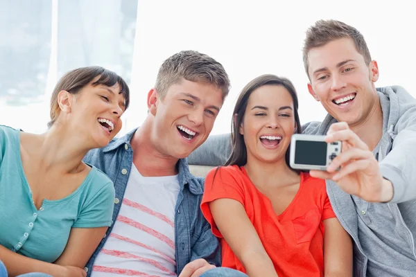 Um grupo rindo posar para uma foto na frente deles — Fotografia de Stock