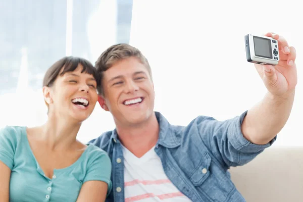 Um casal rindo juntos enquanto posam para uma foto — Fotografia de Stock