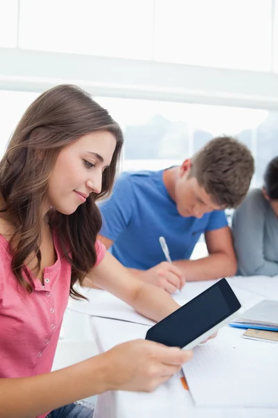 Kobieta, patrząc na jej tabletki podczas studiów — Zdjęcie stockowe