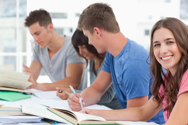 Uma visão lateral de estudar como uma menina olha para a câmera — Fotografia de Stock