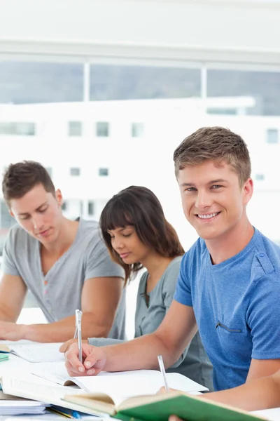 Ein Mann blickt aus dem Studium in die Kamera und lächelt — Stockfoto