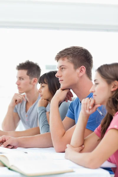 Un grupo de estudiantes sentados en clase escuchando —  Fotos de Stock