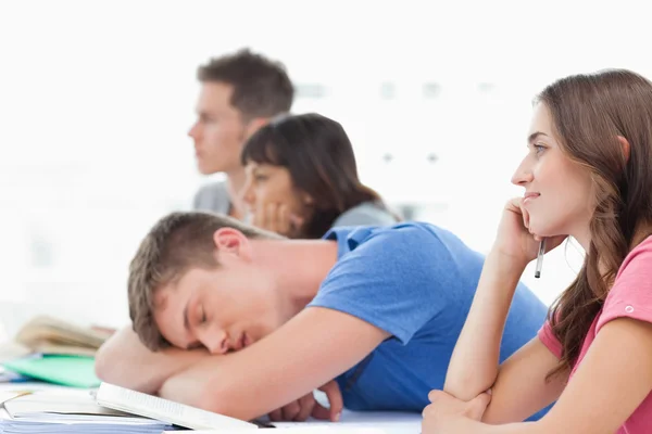 Tres estudiantes escuchando en clase con otro estudiante tomando un —  Fotos de Stock